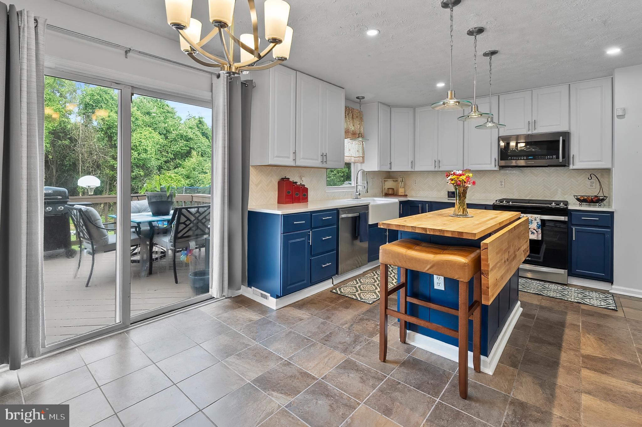 626 Otter Creek Road Edgewood, MD 21040 - Photo 8 of 32 a kitchen with stainless steel appliances granite countertop a stove top oven a sink dishwasher a dining table and chairs with wooden floor