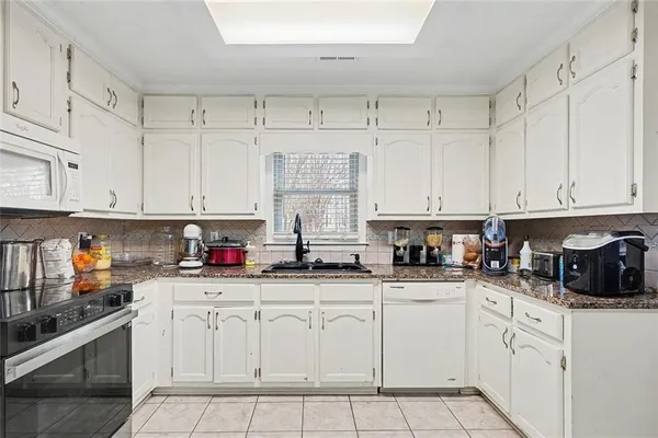 a kitchen with stainless steel appliances granite countertop a refrigerator and cabinets
