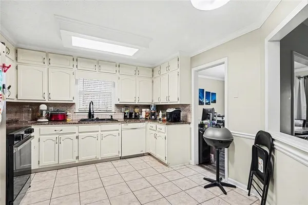 a kitchen with white cabinets and white appliances