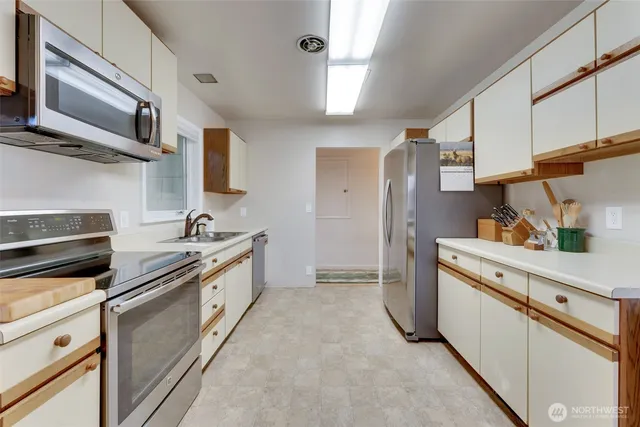 a kitchen with stainless steel appliances granite countertop white cabinets a sink and a stove