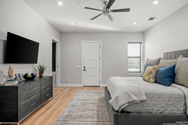 a bedroom with a large bed and a flat screen tv