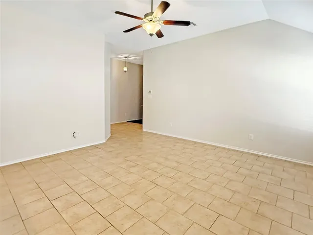 a view of an empty room and a kitchen