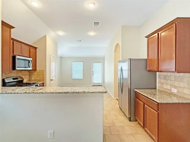 a kitchen with stainless steel appliances granite countertop a stove a sink and a microwave