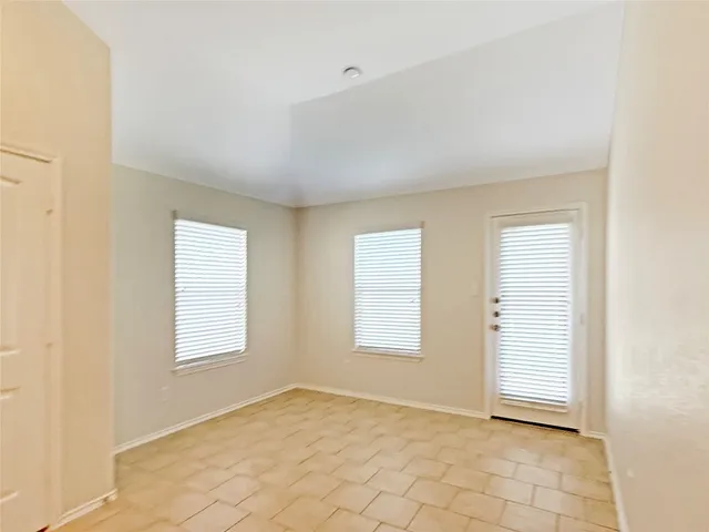 an empty room with wooden floor chandelier fan and windows