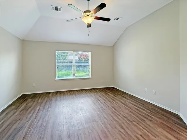 a view of a livingroom with a ceiling fan wooden floor and window