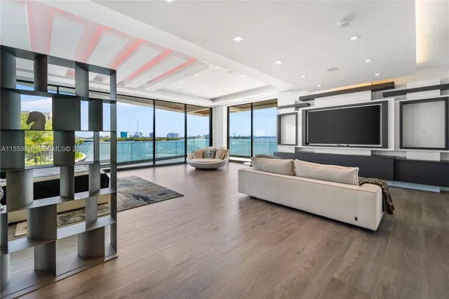 a living room with furniture a large window and chandelier