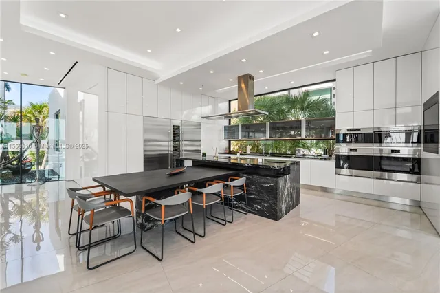 a kitchen with stainless steel appliances a table and chairs