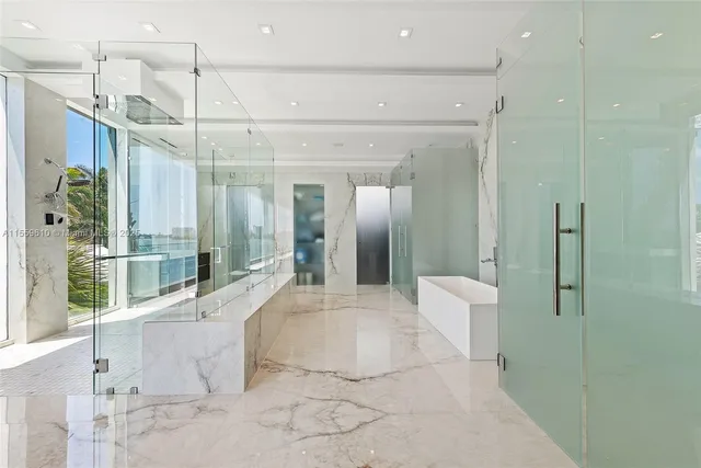 a large white bathroom with a glass shower door