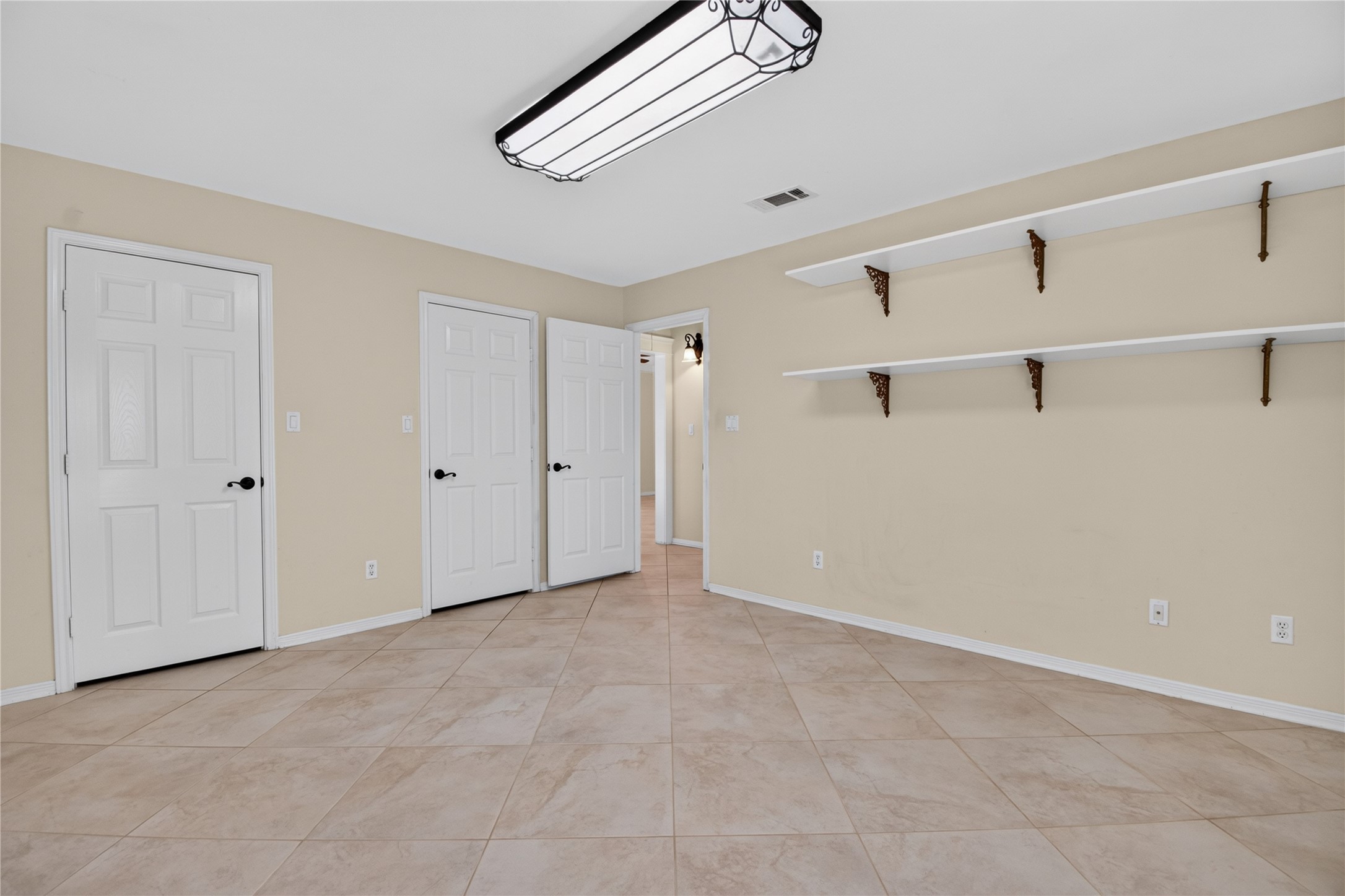 20203 Timber Ridge Drive Magnolia, TX 77355 - Photo 19 of 49 Bright and versatile bedroom with easy-care tile flooring, neutral tones, spacious closet, and custom built-in shelving. Perfect for use as a guest room, home office, or hobby space.