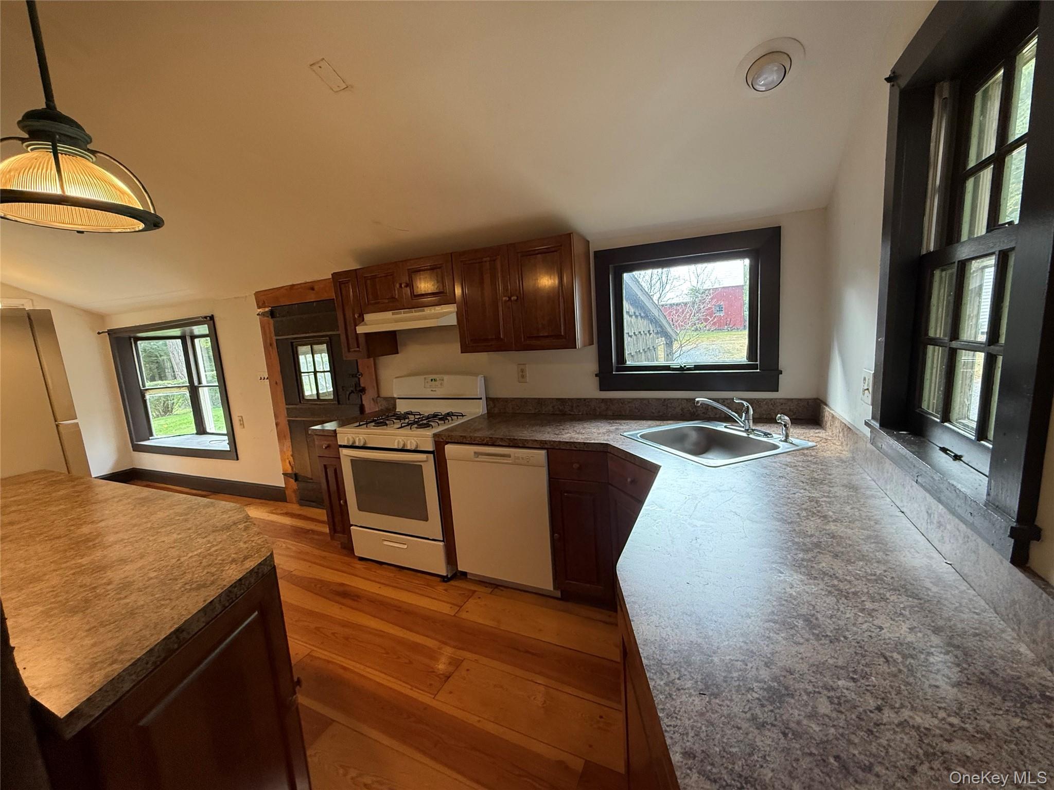241 White Bridge Road Middletown, NY 10940 - Photo 16 of 29 Kitchen featuring white appliances, lofted ceiling, light wood finished floors, decorative light fixtures, and under cabinet range hood