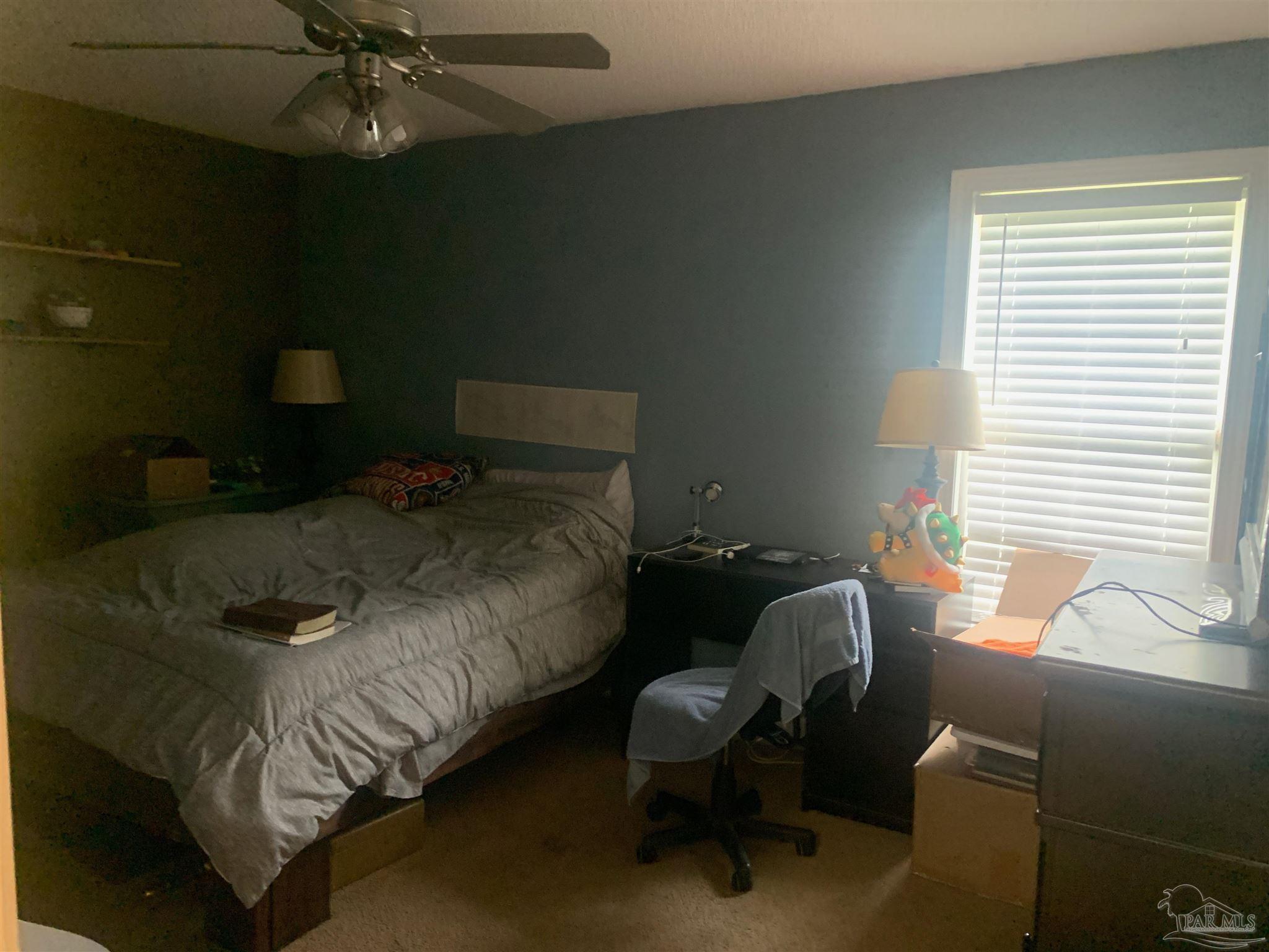 5154 Seneca Trail Milton, FL 32583 - Photo 15 of 20 a bed sitting in a bedroom next to a window