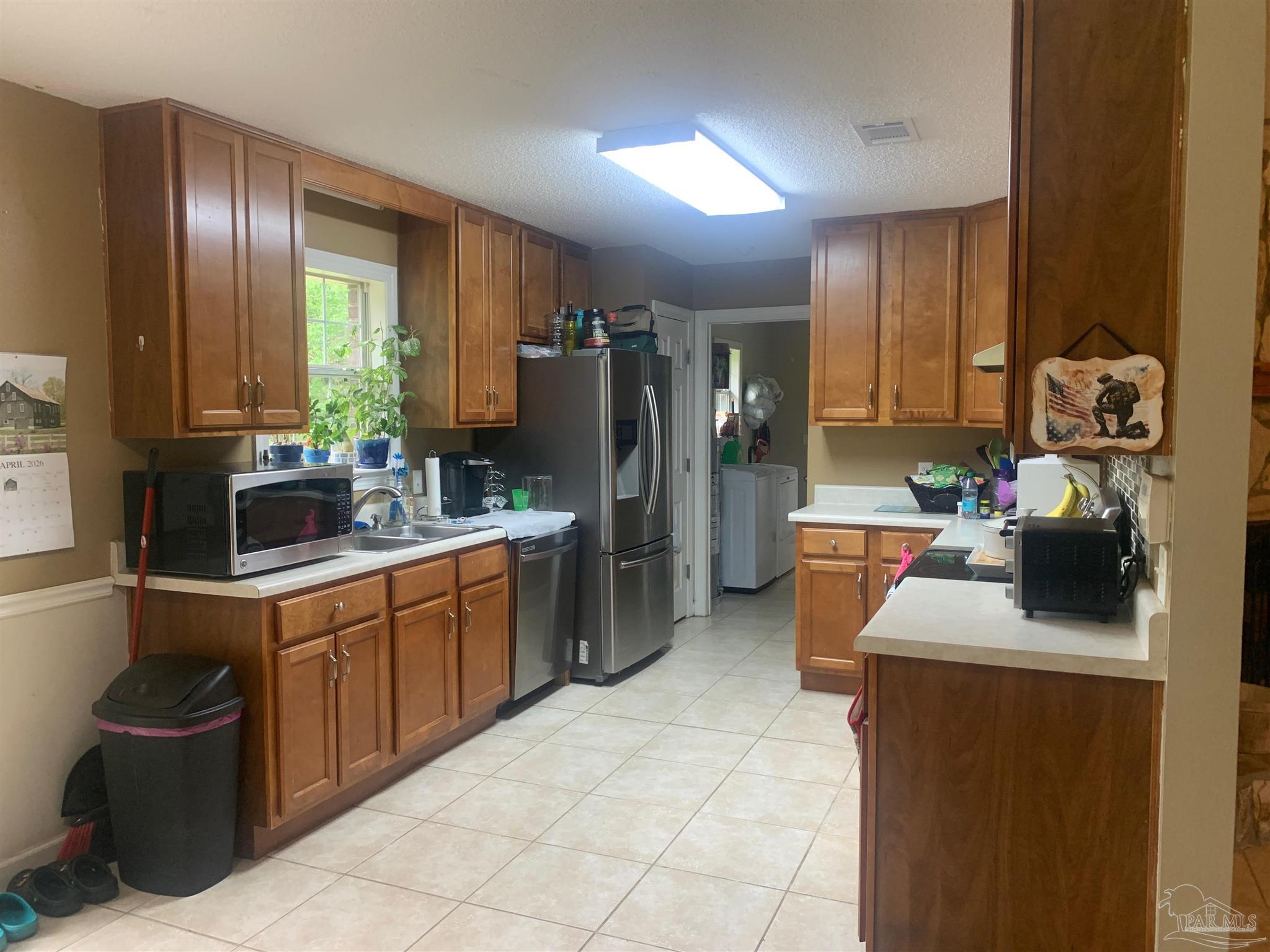 5154 Seneca Trail Milton, FL 32583 - Photo 17 of 20 a kitchen with refrigerator and cabinets