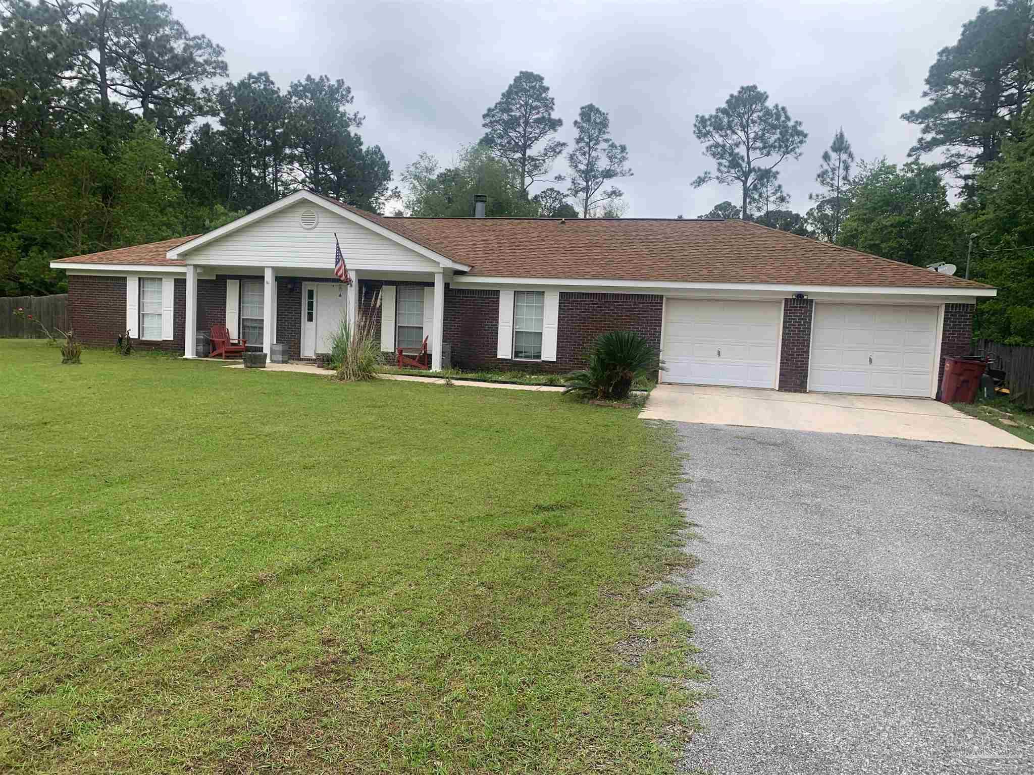 5154 Seneca Trail Milton, FL 32583 - Photo 3 of 20 a front view of a house with a garden