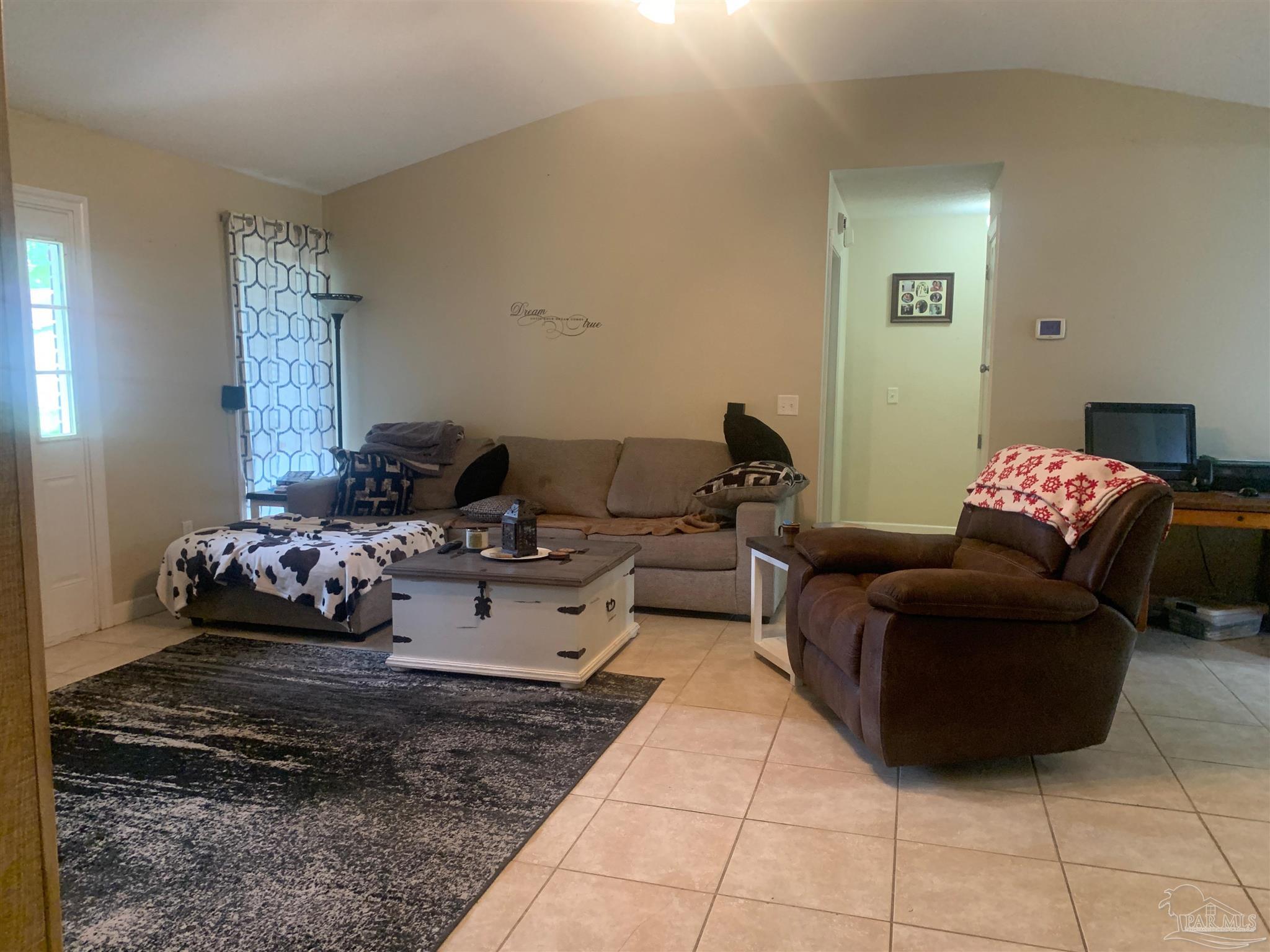 5154 Seneca Trail Milton, FL 32583 - Photo 10 of 20 a living room with furniture and painting on the wall