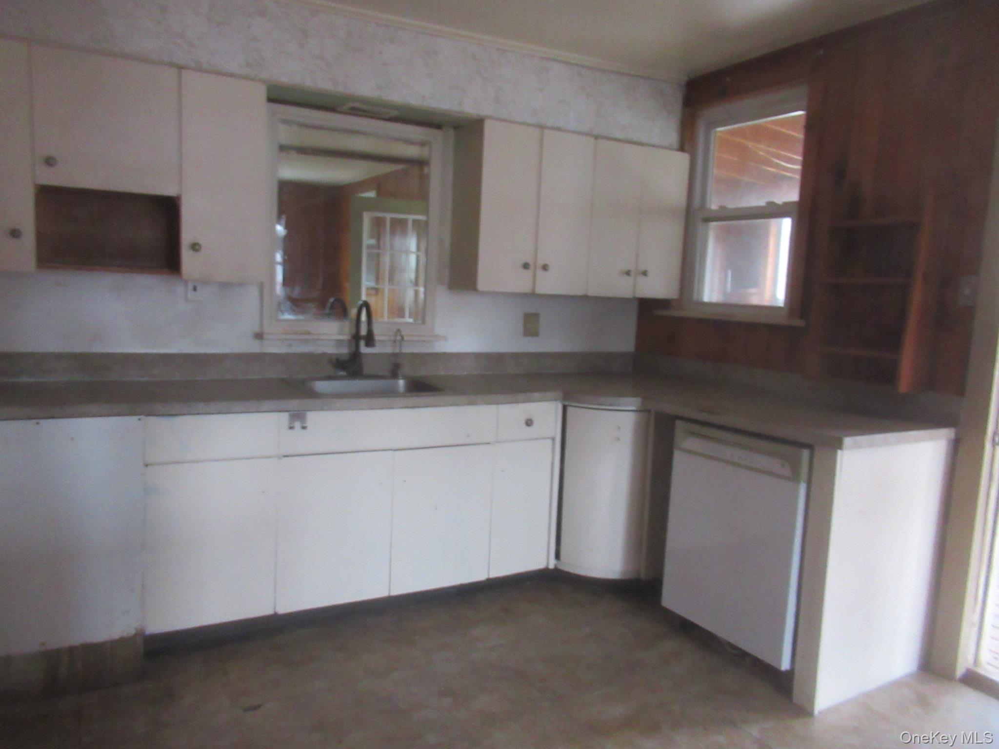 162 Osborne Hill Road Fishkill, NY 12524 - Photo 7 of 11 Kitchen with white dishwasher, open shelves, plenty of natural light, and white cabinets