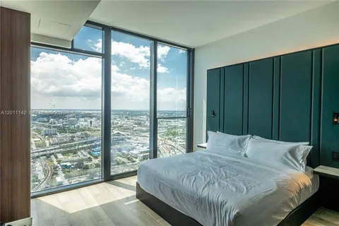 a bedroom with a large window and a balcony
