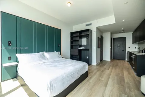a large bedroom with a bed and a television
