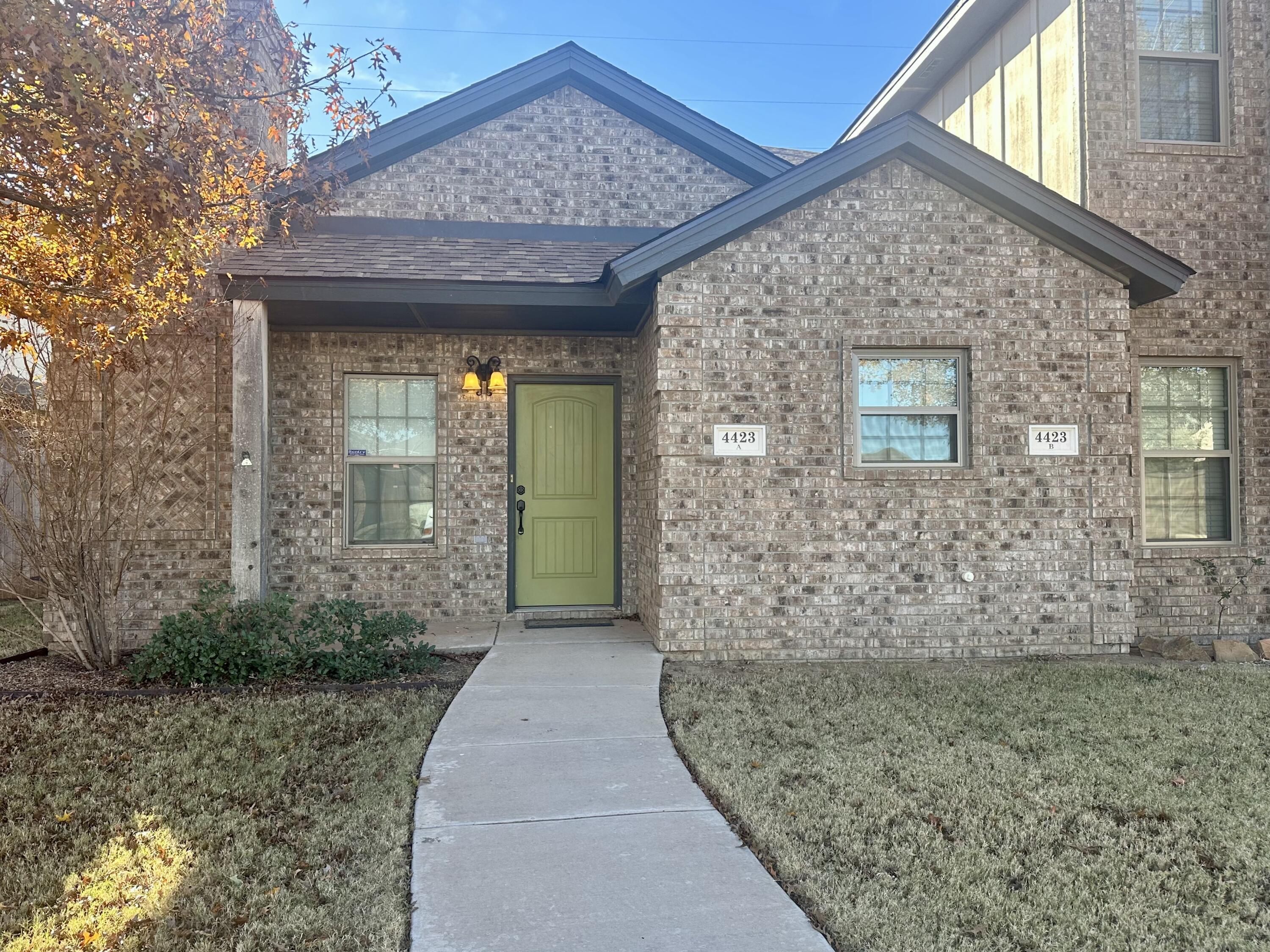 4423 106th Street, Unit A Lubbock, TX 79424 - Photo 1 of 23 a front view of a house with a garden
