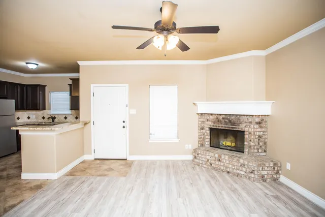 a view of a livingroom with a fireplace and wooden floor