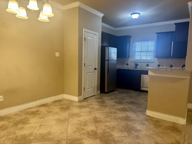 a view of a kitchen with refrigerator and windows