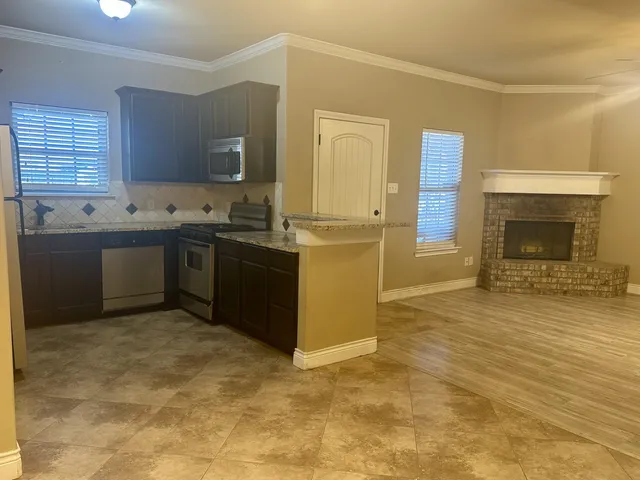 a kitchen with stainless steel appliances granite countertop a stove sink and cabinets