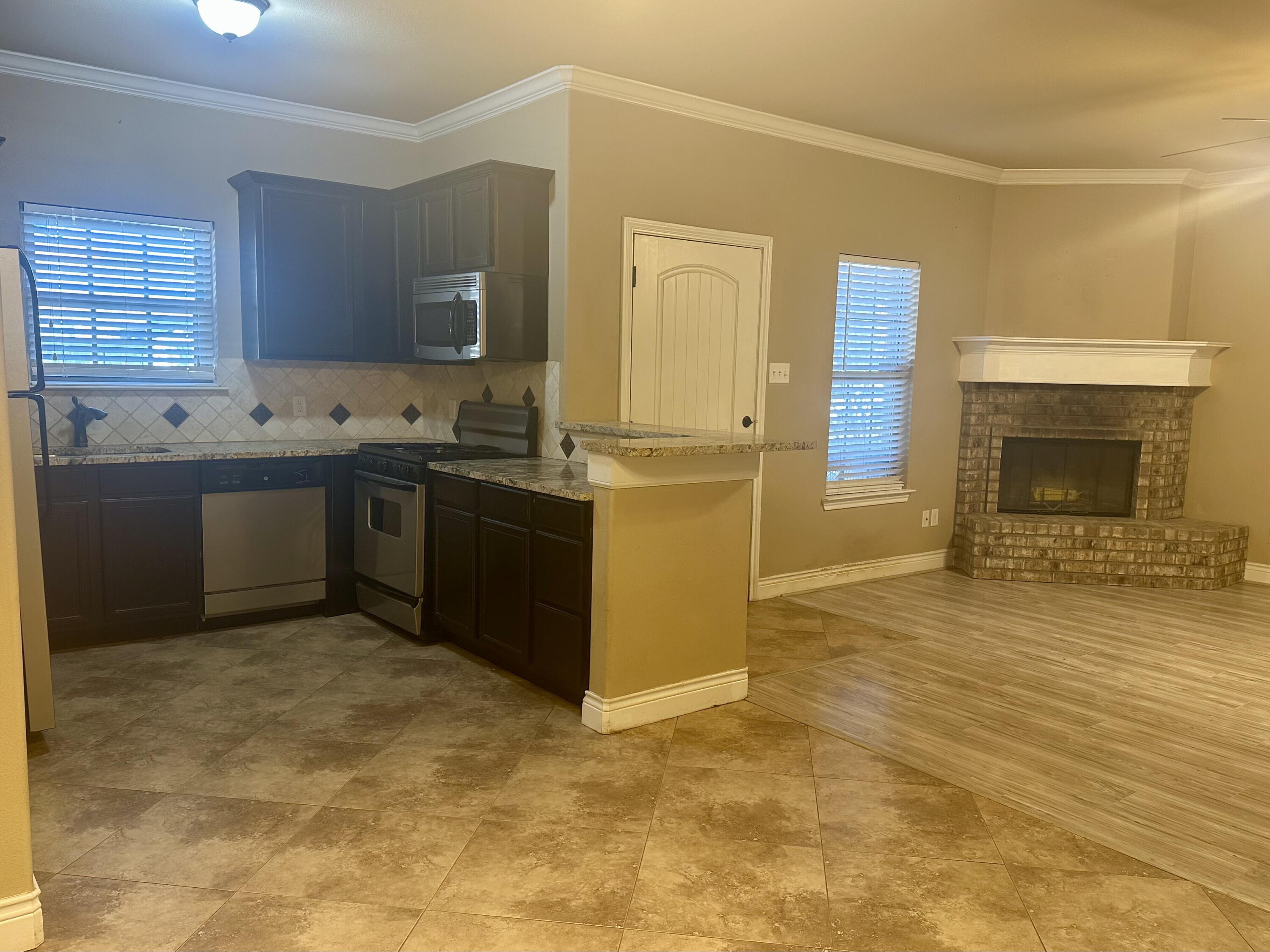 4423 106th Street, Unit A Lubbock, TX 79424 - Photo 8 of 23 a kitchen with stainless steel appliances granite countertop a stove sink and cabinets