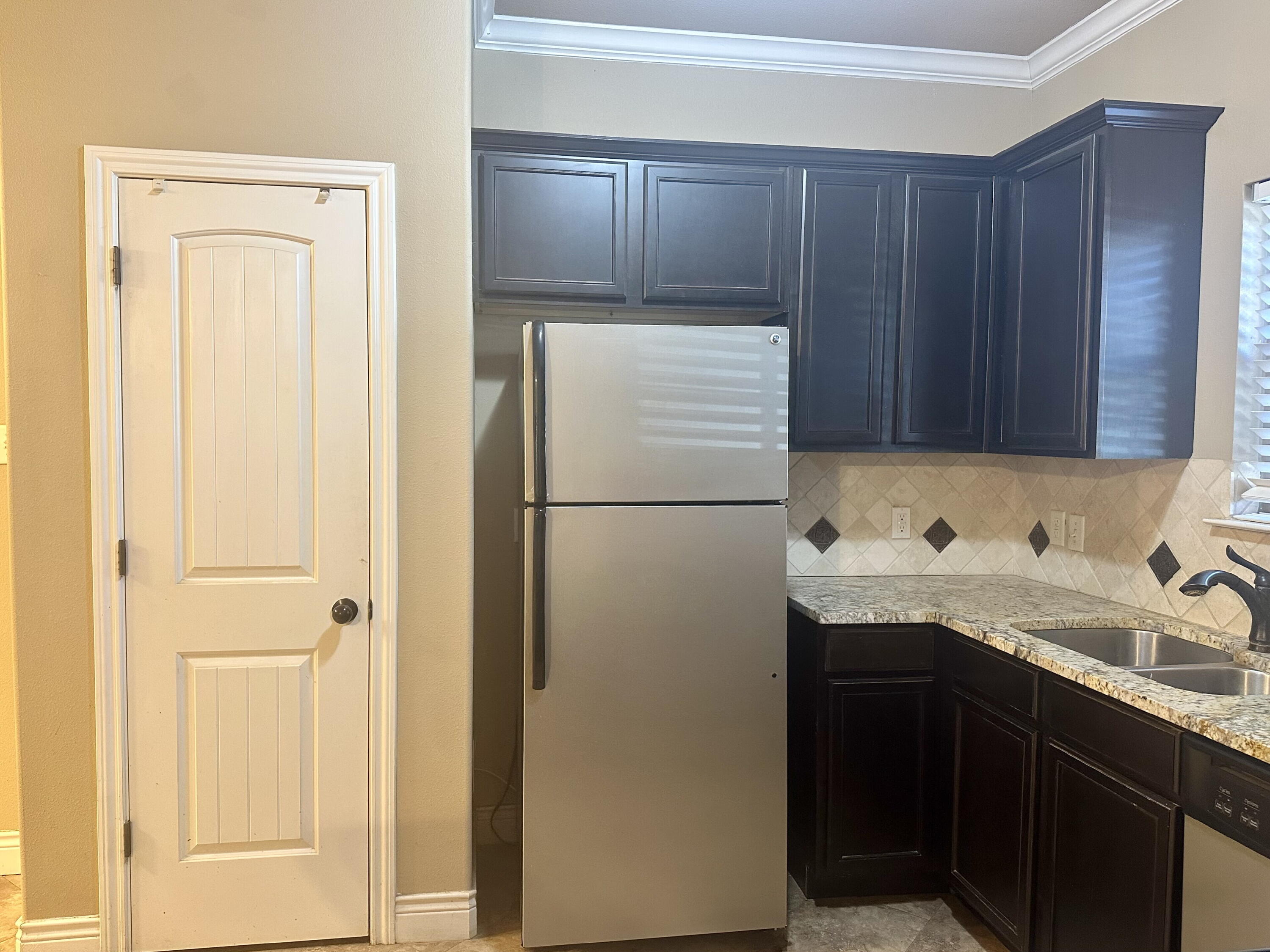 4423 106th Street, Unit A Lubbock, TX 79424 - Photo 9 of 23 a kitchen with a sink and a refrigerator