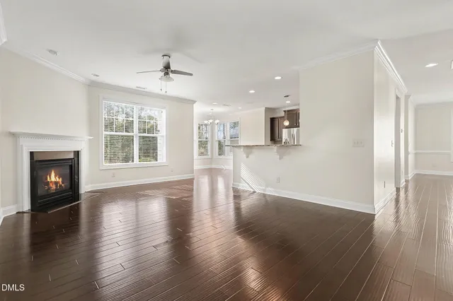 a view of empty room with wooden floor and a window