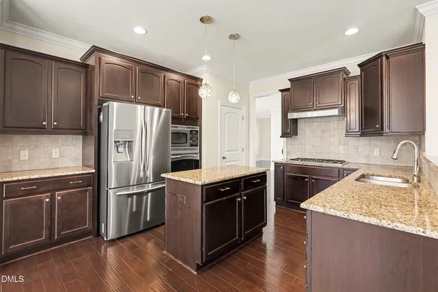 a kitchen with a refrigerator sink and wooden cabinets