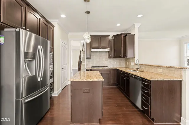 a kitchen with stainless steel appliances granite countertop a refrigerator and a sink