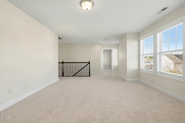 an empty room with a ceiling fan and window