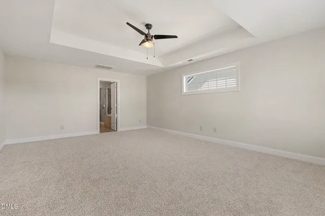 a spacious bathroom with a granite countertop sink a toilet a mirror and a vanity