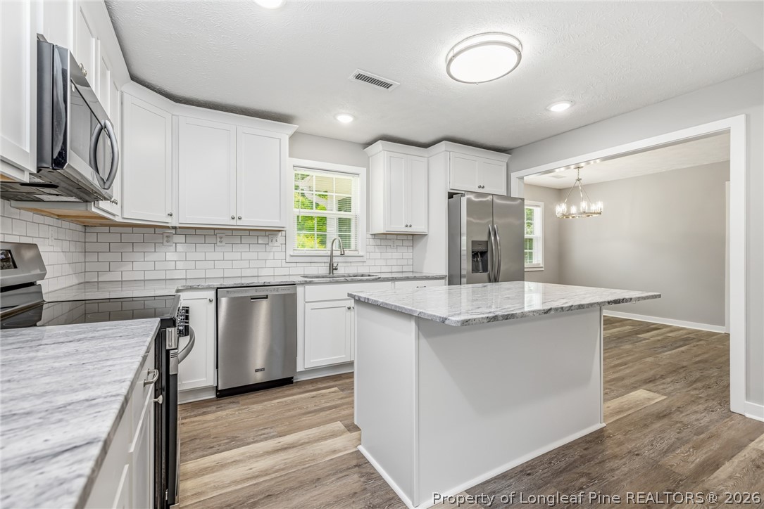 3524 Pine Log Road Lumberton, NC 28360 - Photo 10 of 42 a kitchen with stainless steel appliances granite countertop a sink stove and refrigerator
