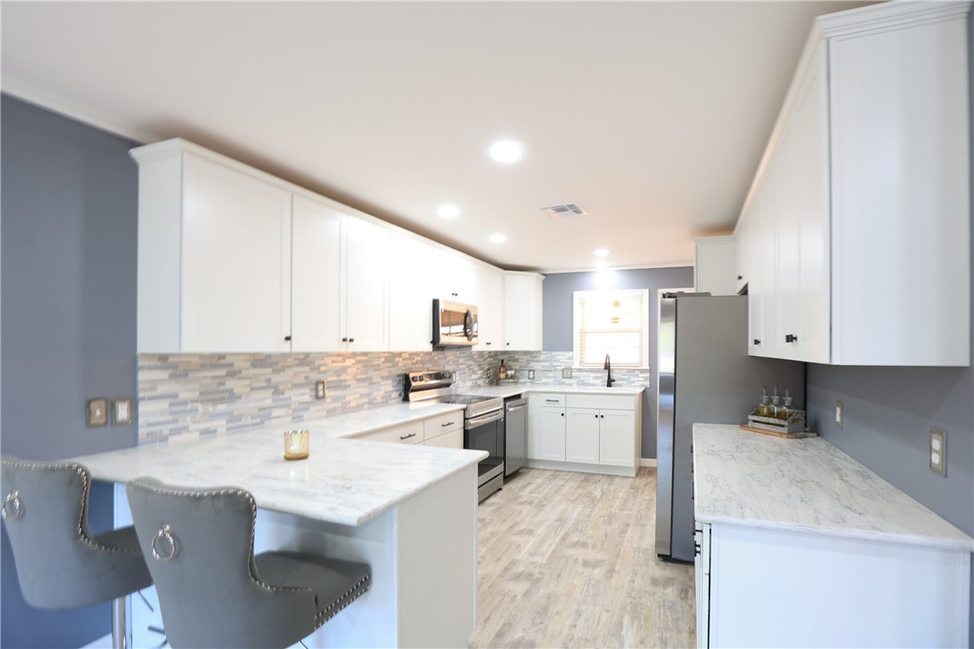 700 North Cameron Street Alice, TX 78332 - Photo 3 of 15 a kitchen with refrigerator and cabinets