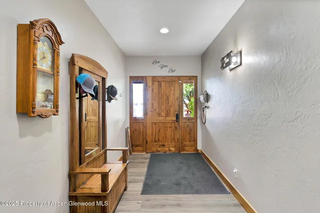 a view of a hallway with wooden floor and furniture