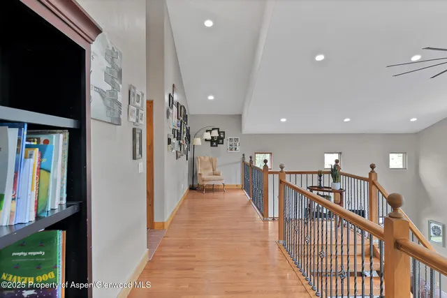 a view of a hallway with wooden floor and stairs