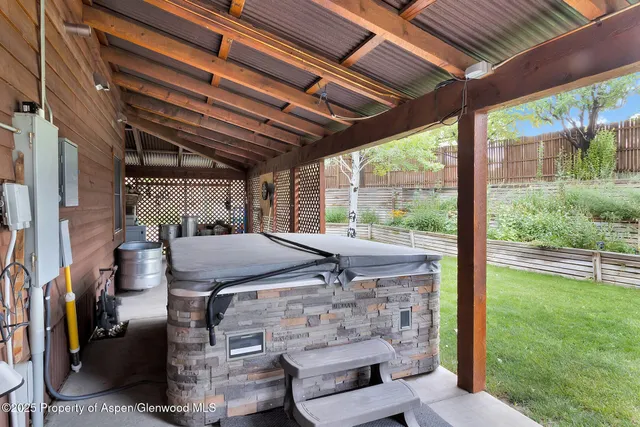 a view of a porch with a table and chairs under an umbrella
