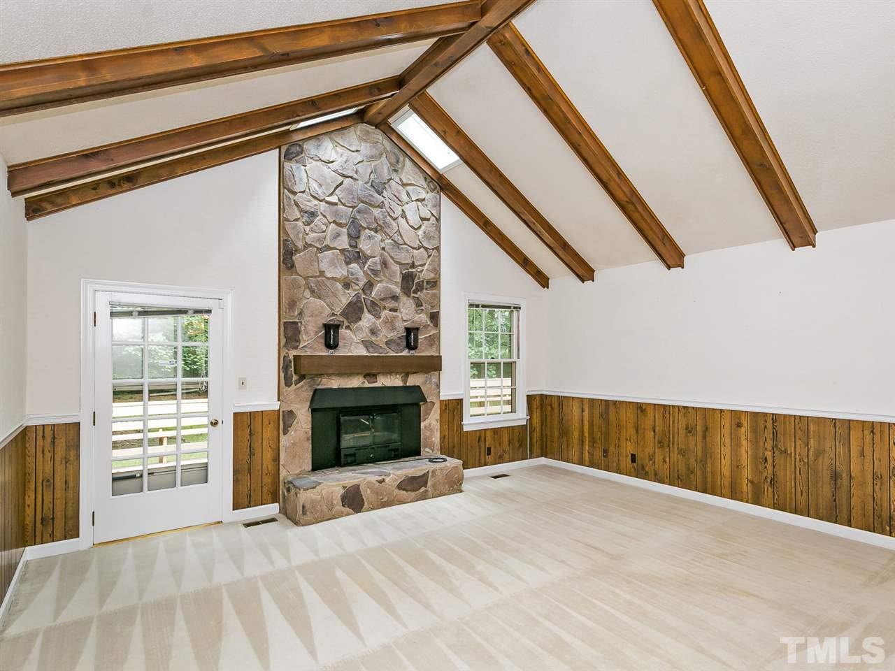 6116 Bayberry Lane Raleigh, NC 27612 - Photo 2 of 25 Cathedral ceilings with wood beams and stone fireplace with gas logs create a great space to relax or entertain family and friends.