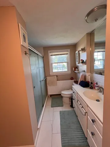 a large bathroom with a double vanity sink a large mirror and a toilet