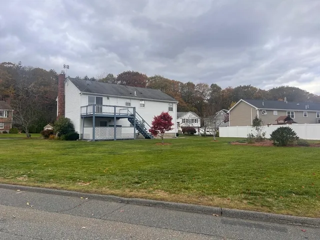 a view of a house with a big yard and large trees