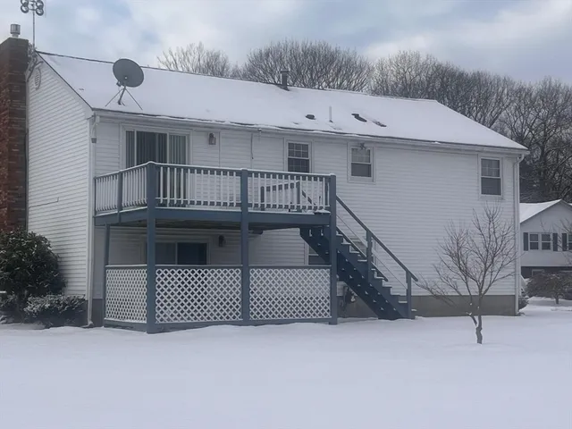 a view of a white house with large windows and a small yard