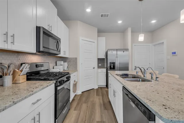 a kitchen with stainless steel appliances granite countertop a sink stove and refrigerator