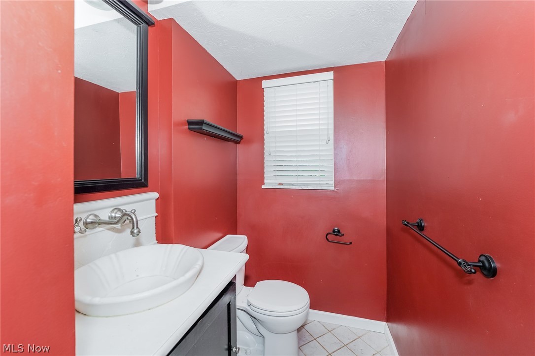 215 Randel Avenue Akron, OH 44313 - Photo 15 of 20 Bathroom featuring a textured ceiling, vanity, tile floors, and toilet