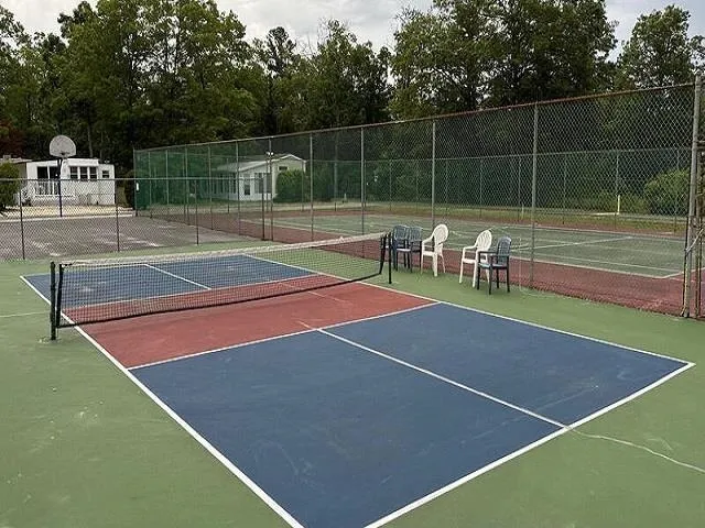 a view of a patio with table and chairs with wooden floor and fence