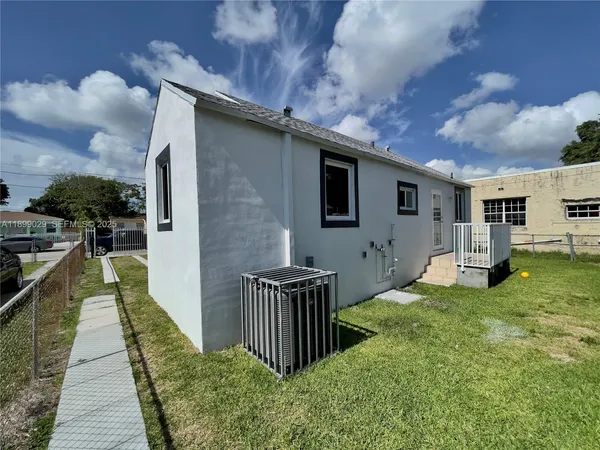 a view of a house with backyard and sitting area