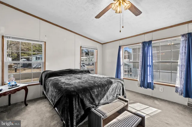 a bed sitting in a spacious bedroom next to a window