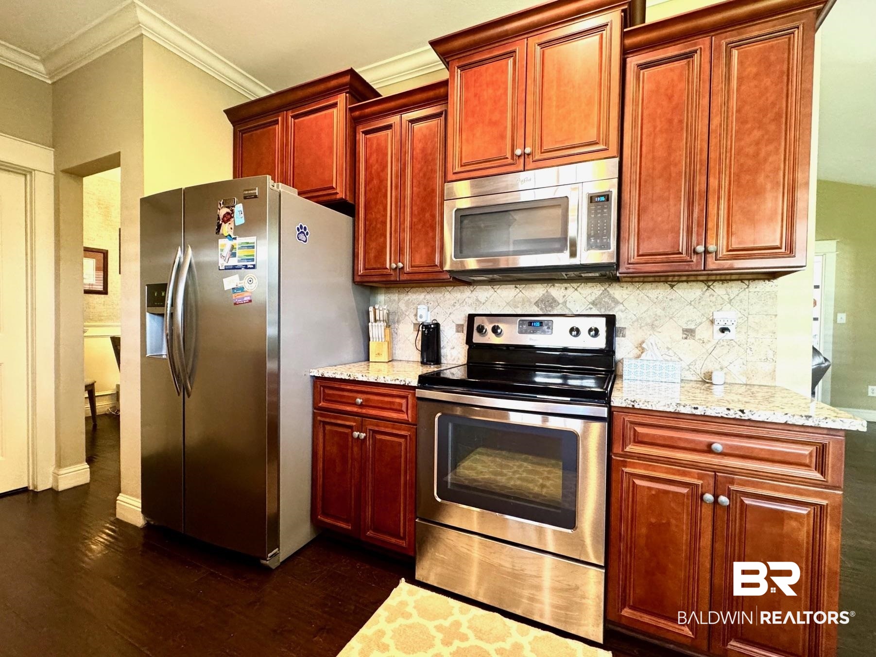 1030 Crown Walk Drive Foley, AL 36535 - Photo 8 of 40 Kitchen with dark wood-type flooring, crown molding, tasteful backsplash, and appliances with stainless steel finishes