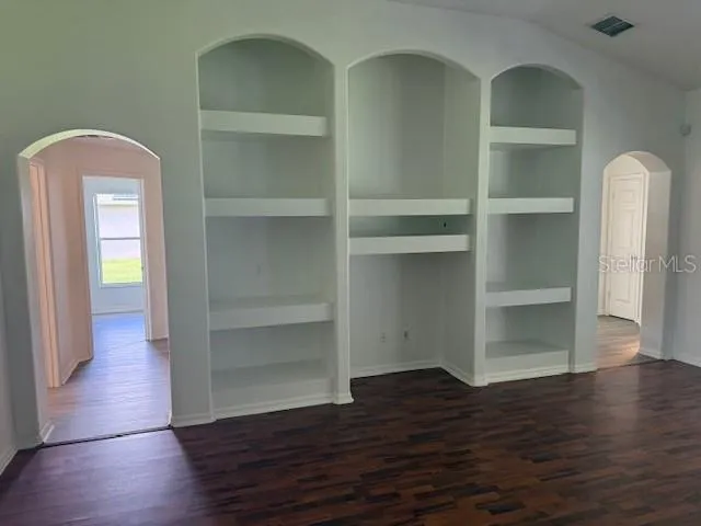 a view of empty room with wooden floor
