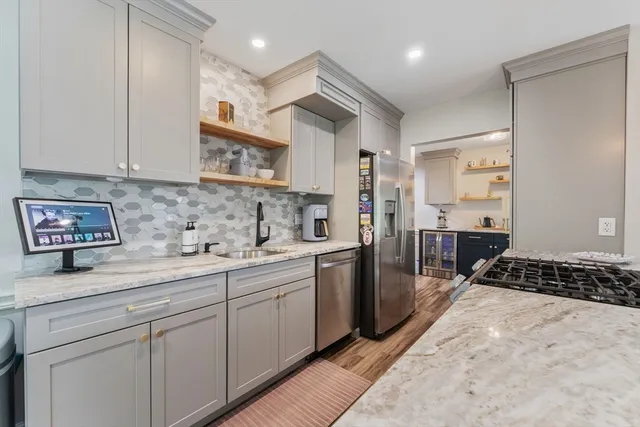 a kitchen with stainless steel appliances a sink stove and cabinets