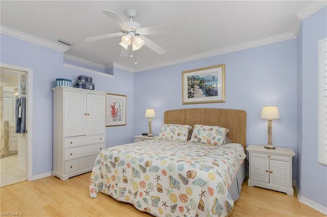 a bedroom with a large bed and a chandelier